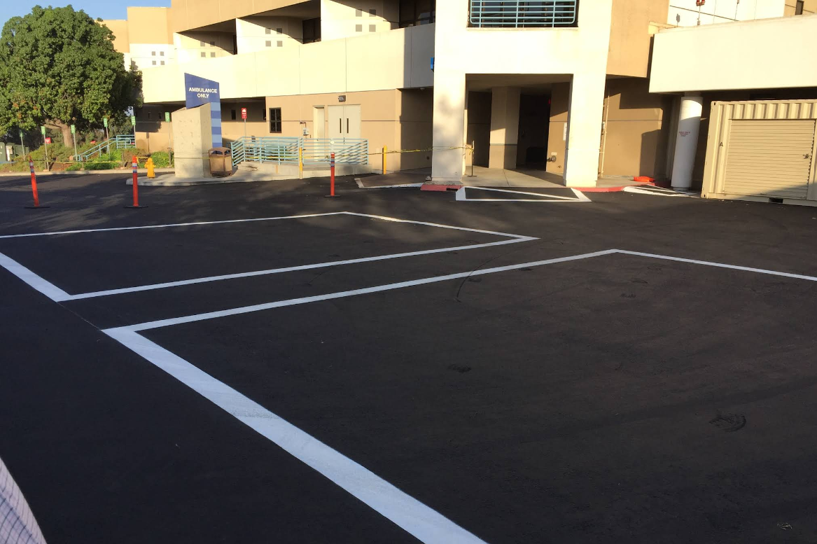 Freshly paved medical center parking lot with white line striping