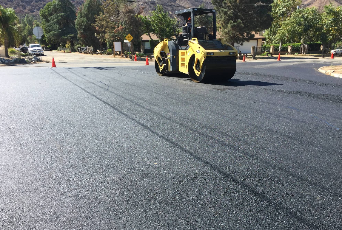 Road paving with heavy roller compactor on residential street